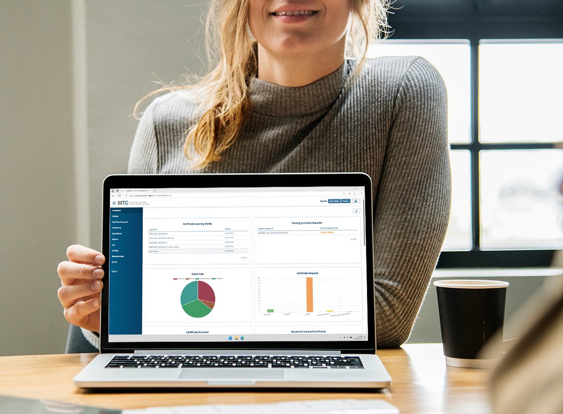 Frau hält aufgeklappten Laptop mit Screen der Verwaltungsoberfläche der 360° Managed PKI & CLM in die Kamera.